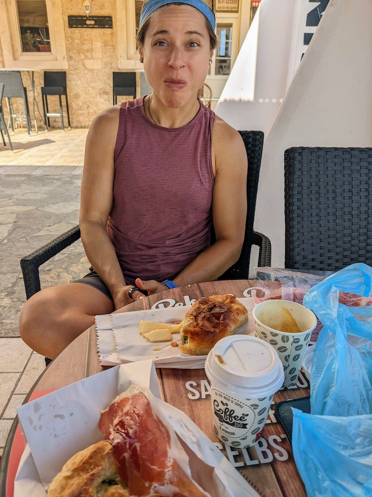 woman eating meat, cheese, bread, and espresso in supetar on prosciutto in supetar on Brač