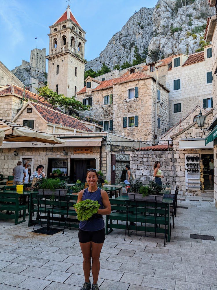 woman in the old town or omis, croatia after buying veggies at the local market.