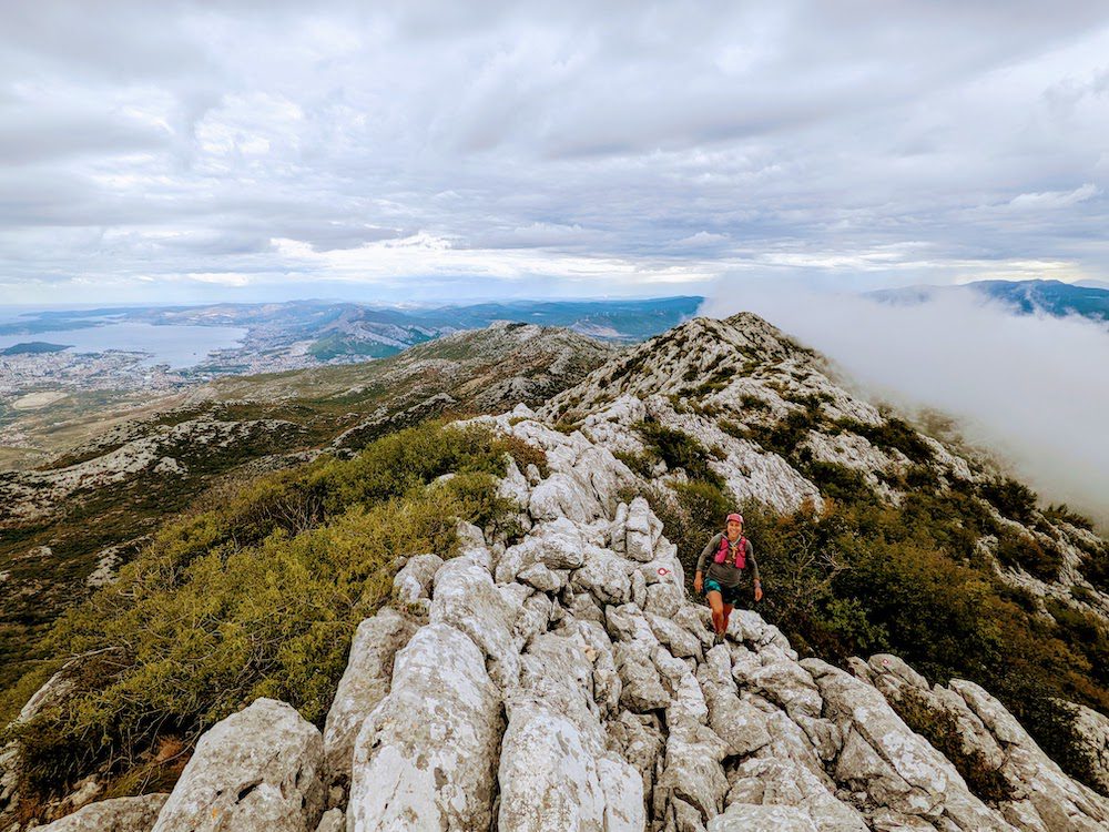woman hiking along a ridge in croatia with Split in the background