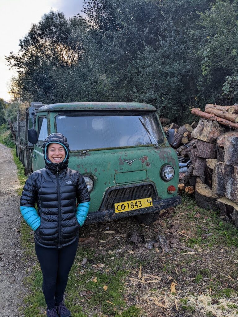 woman standing next to a green soviet-era work truck in bulgaria