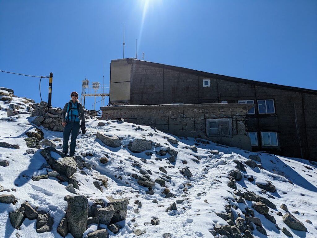 woman hiking on snow near the hut at the top of Musala in bulgaria