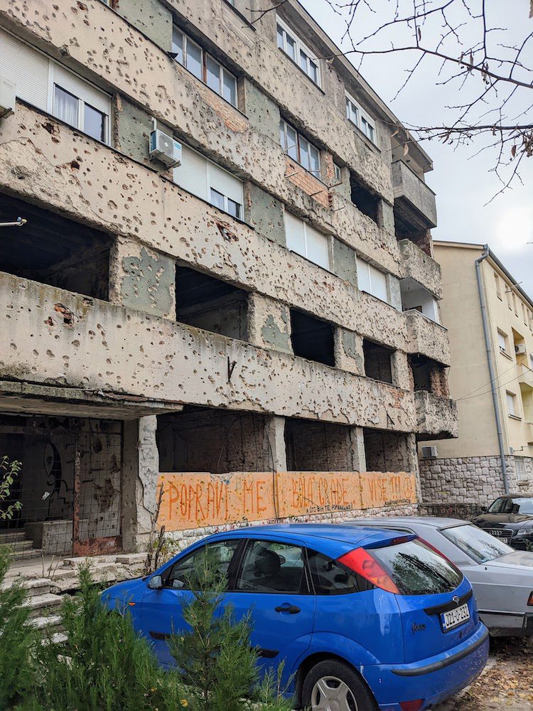 Bullet holes pockmark a partially abandoned building in central Mostar.